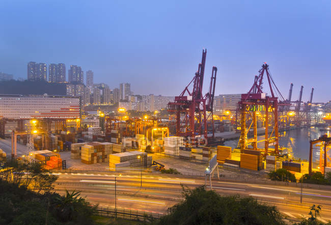 Frachtcontainer und Ladekräne nachts beleuchtet, Hongkong, China — Stockfoto
