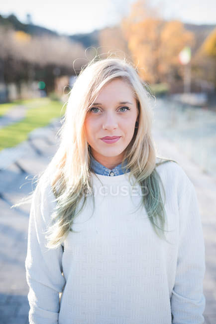 Portrait of smiling young woman in park — Stock Photo