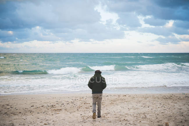 Vista posteriore dell'uomo sulla spiaggia ventosa, Sorso, Sassari, Sardegna, Italia — Foto stock