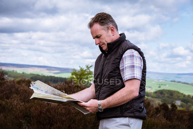 Caminante masculino leyendo mapa en páramos de brezo, Pateley Bridge, Nidderdale, Yorkshire Dales - foto de stock
