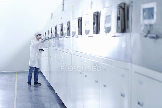Trabajador masculino en la fábrica de baterías de cigarrillos electrónicos, Guangdong, China - foto de stock