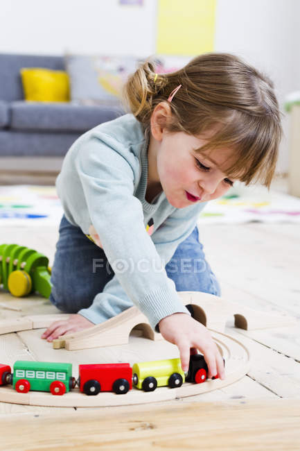 Девушка играет с игрушечными машинами дома — стоковое фото