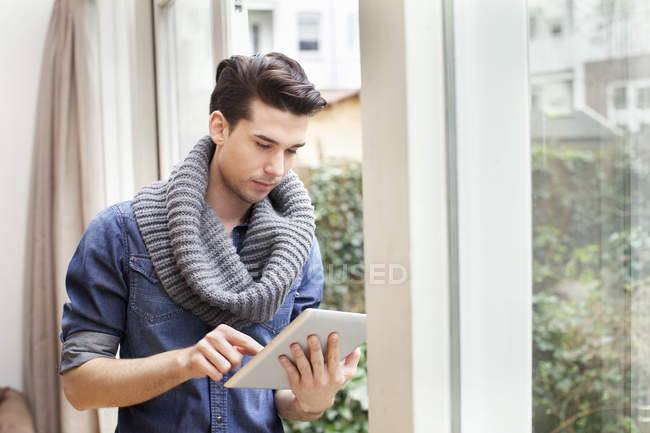 Young man using digital tablet in living room — Stock Photo