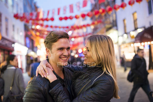 Pareja joven romántica en la calle por la noche, Chinatown, Londres, Inglaterra, Reino Unido - foto de stock