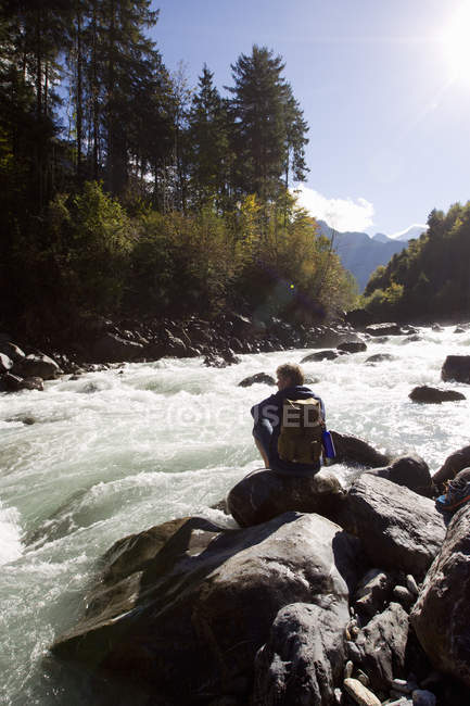 Rückansicht eines männlichen Wanderers auf Flussfelsen, Grindelwald, Schweiz — Stockfoto