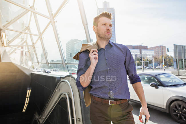 Ritratto di uomo d'affari che guarda lontano contro gli edifici — Foto stock