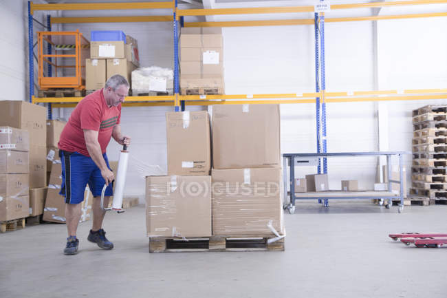 Worker packing boxes at healthcare warehouse — Stock Photo