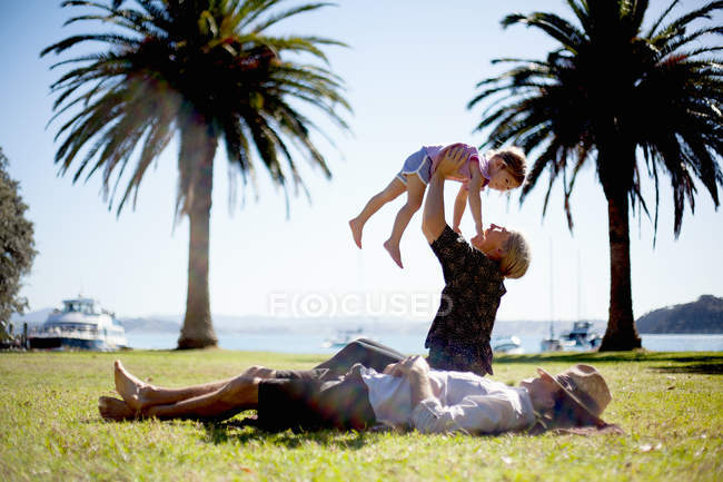 Mother lifting up daughter in park, New Zealand — Stock Photo