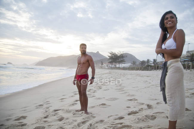 Metà coppia adulta in piedi sulla spiaggia in costume da bagno — Foto stock