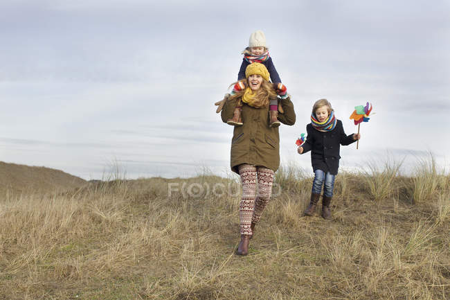 Sorridente metà donna adulta con figlia e figlio a costa — Foto stock