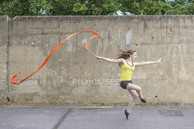 Молода жінка практикує стрічковий танець на дворі — стокове фото