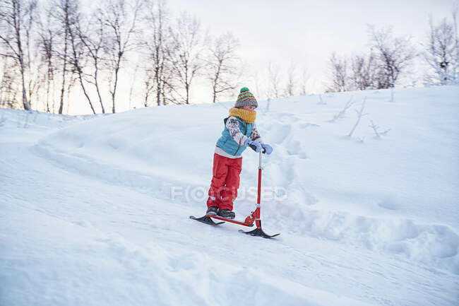 Ragazzo sulla neve scooter in discesa collina, Hemavan, Svezia — Foto stock