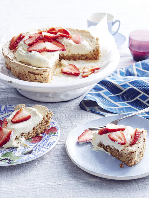 Strawberry and meringue cake on plates on table — Stock Photo