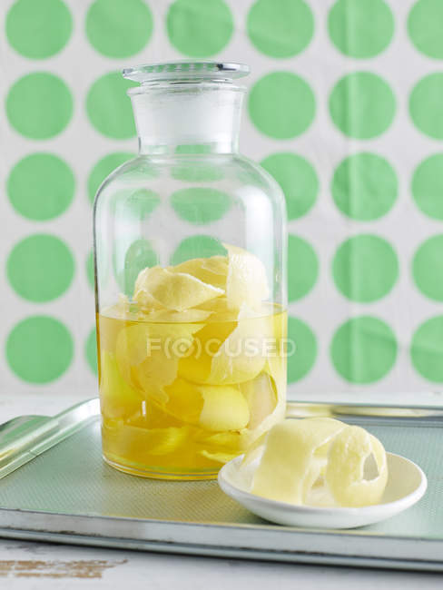 Close up of lemon iced tea with lemon peel in jar — Stock Photo