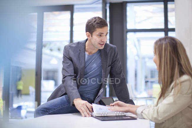 Deux employés de bureau masculins et féminins en discussion — Photo de stock