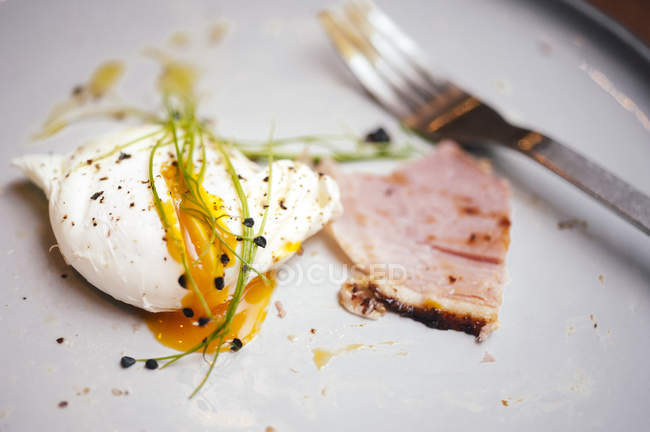Poached egg with fork on plate — Stock Photo