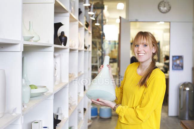 Frau hält Keramikvase in Werkstatt — Stockfoto
