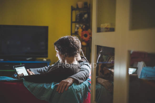 Coppia seduta sul divano, guardando tablet digitale — Foto stock