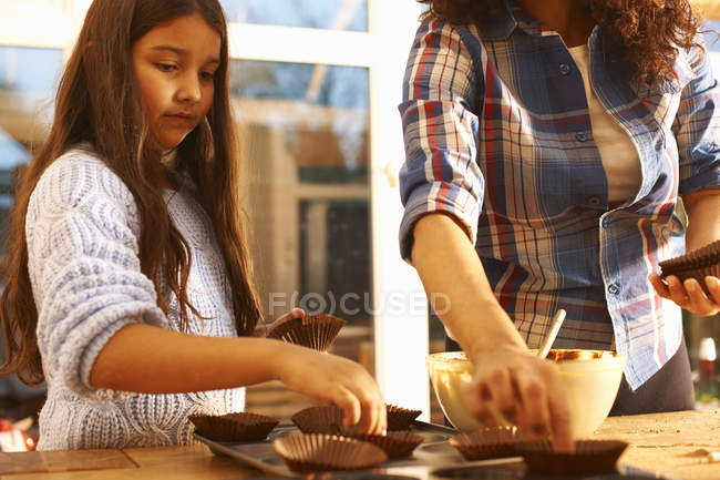 Мать и дочь пекут дома на кухне — стоковое фото