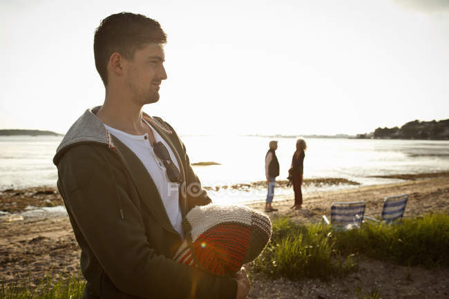 Young man holding blanket on Bournemouth beach, Dorset, UK — Stock Photo