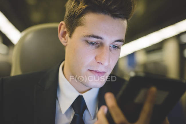 Porträt eines jungen Geschäftsmannes, der mit digitalem Tablet im Zug pendelt. — Stockfoto