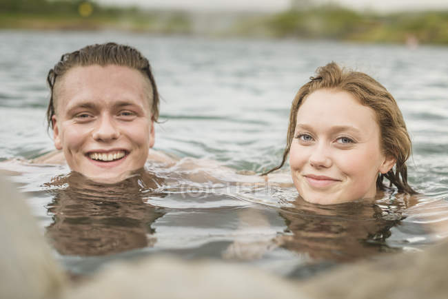 Retrato do jovem casal relaxante na fonte termal Secret Lagoon (Gamla Laugin), Fludir, Islândia — Fotografia de Stock