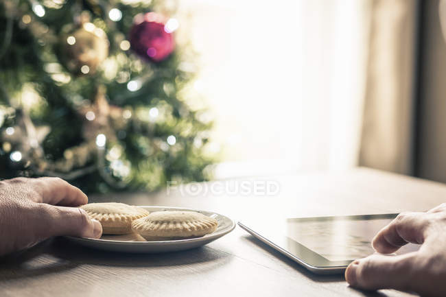 Человек, использующий цифровой планшет с мясными пирогами — стоковое фото