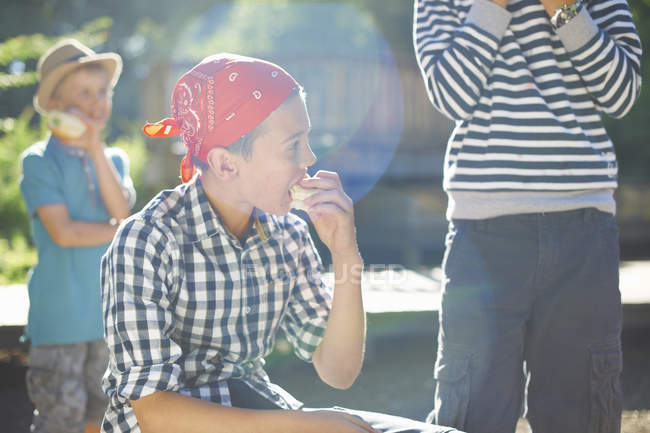 Três meninos almoçando no parque — Fotografia de Stock