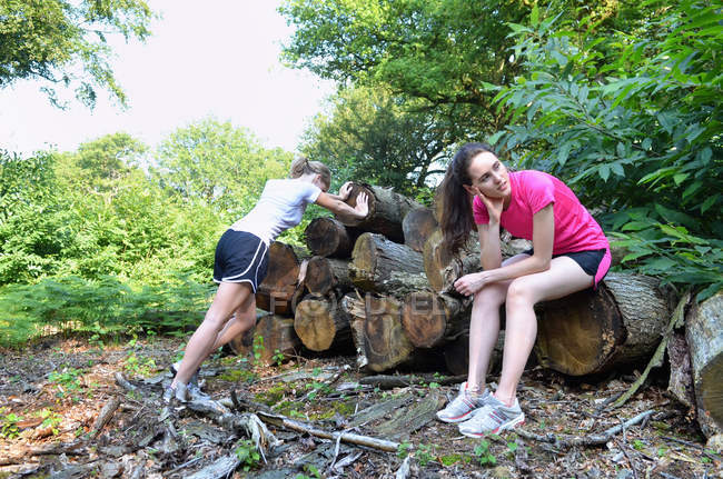 Dos jóvenes corredoras tomando un descanso en el bosque - foto de stock