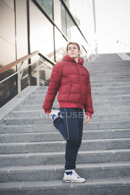 Junge Läuferin wärmt sich auf der Stadttreppe auf — Stockfoto
