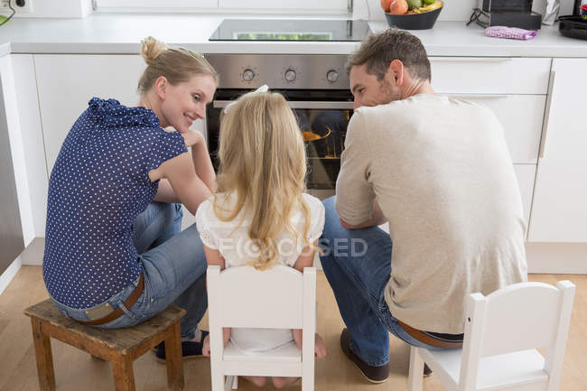 Família assistindo forno em casa — Fotografia de Stock