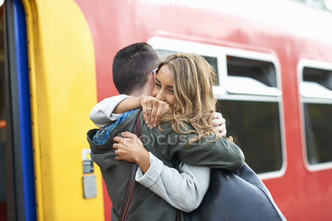 Heterosexual couple hugging at railway station — Stock Photo