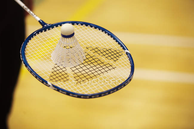 Shuttlecock on top of badminton racket — Stock Photo