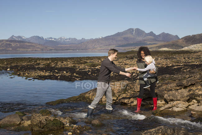Madre sosteniendo al hijo por Loch Eishort, Isla de Skye, Hébridas, Escocia - foto de stock