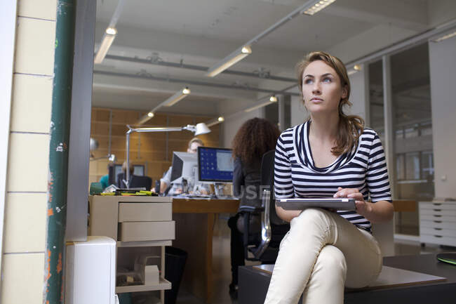 Молода жінка використовує цифровий планшет в офісі — стокове фото