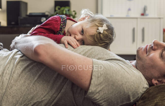 Daughter lying on fathers chest — Stock Photo