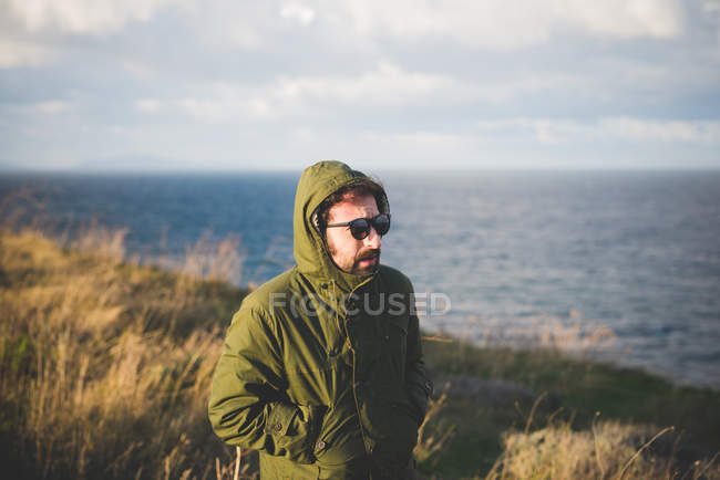 Mittlerer erwachsener Mann, der entlang der windigen Küste schlendert, sorso, sassari, sardinien, italien — Stockfoto