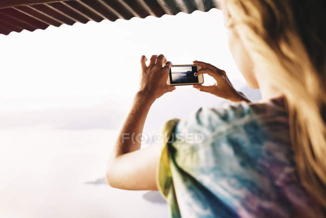 Через плечо вид молодой женщины, фотографирующей озеро Атитлан, Гватемала — стоковое фото