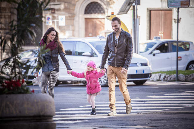 Couple and daughter holding hands on pelican crossing, Cagliari, Sardinia, Italy — Stock Photo