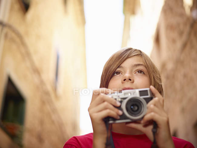 Close-up of boy photographing village street using SLR camera, Majorca, Spain — Stock Photo