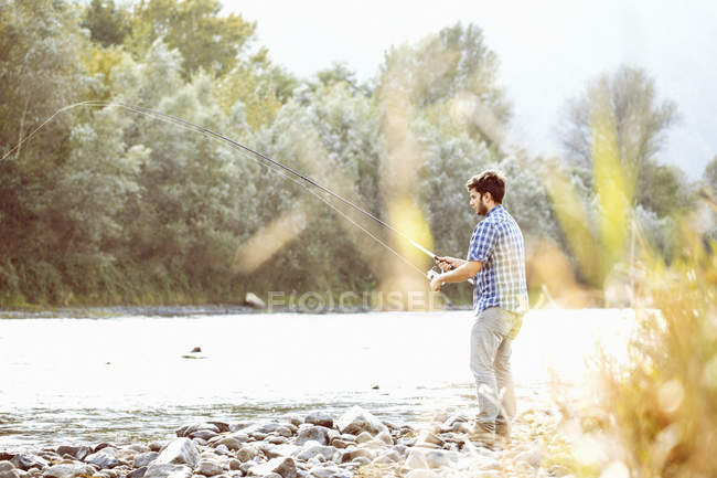Jeune homme pêchant dans la rivière, Premosello, Verbania, Piemonte, Italie — Photo de stock