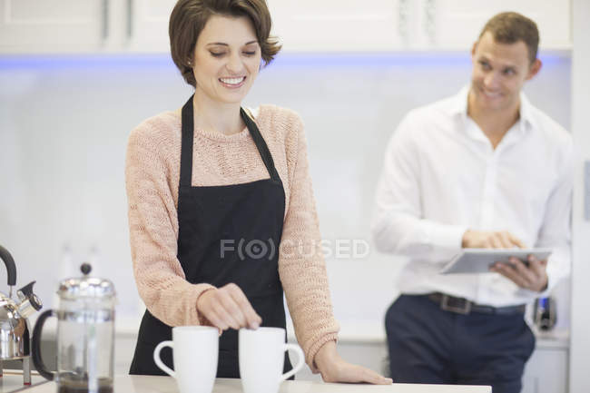 Cheerful couple taking a coffee break in kitchen — Stock Photo
