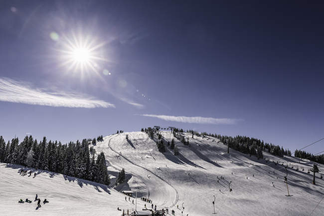 Солнечный свет над заснеженным горнолыжным склоном, Шеффау, Тироль, Австрия — стоковое фото