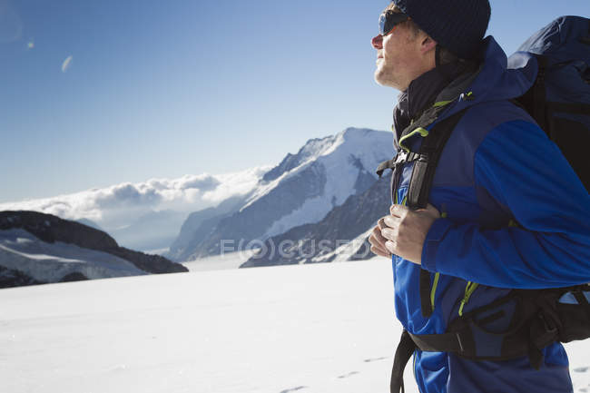 Senderista masculino en paisaje montañoso cubierto de nieve, Jungfrauchjoch, Grindelwald, Suiza - foto de stock