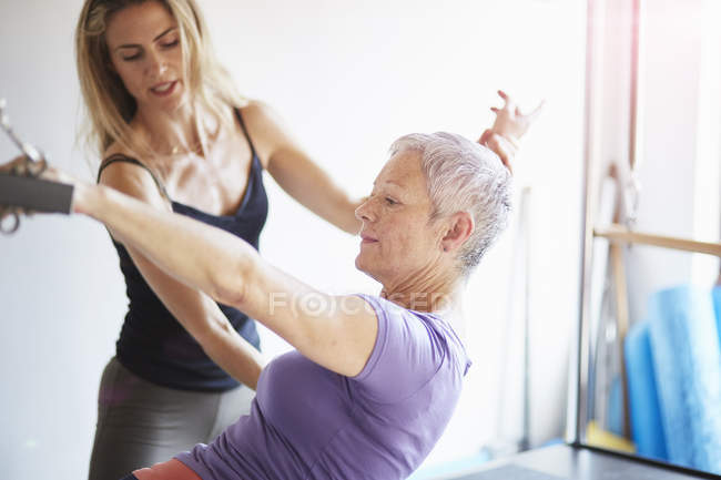 Female student and teacher practicing pilates on trapeze table in pilates gym — Stock Photo