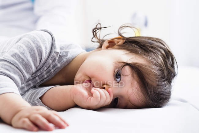 Малыш лежит, сосёт большой палец. — стоковое фото