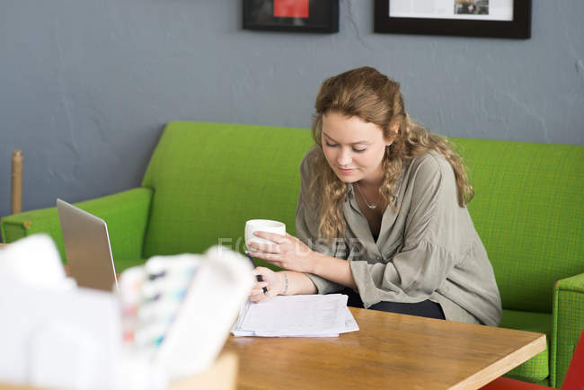 Молода жінка-дизайнер, що працює з офісного дивана — стокове фото