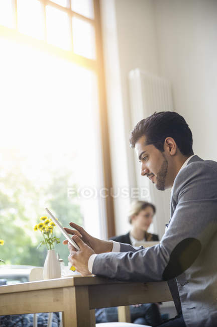 Человек, использующий цифровой планшет в кафе — стоковое фото