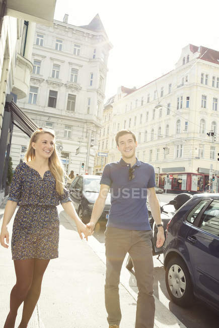 Jeune couple flânant dans la rue de la ville — Photo de stock