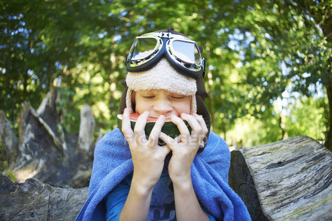 Мальчик в маскарадном платье, ест арбуз в парке — стоковое фото